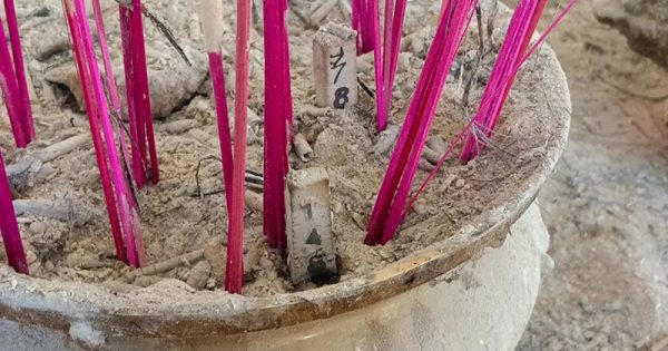 คอหวยจุดธูปเลขเด็ด - "Lottery fans light incense sticks for lucky numbers."